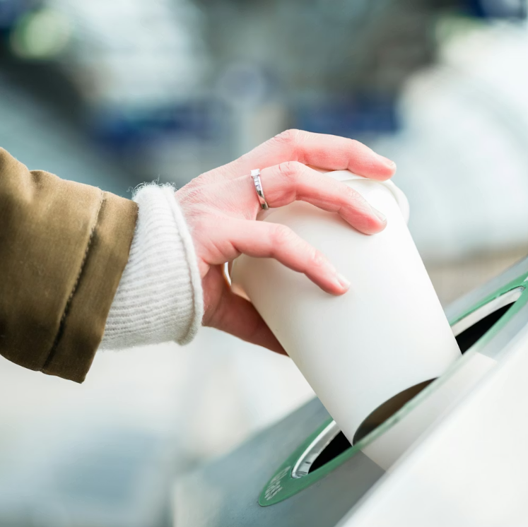 Recycling coffee cup in bin