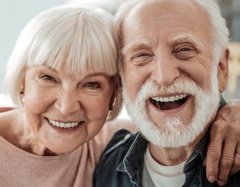 Smiling elderly couple embracing joyfully
