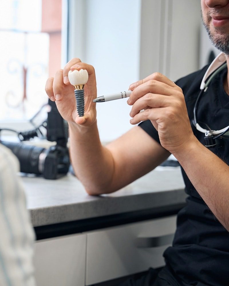 Dentist explaining dental implant model