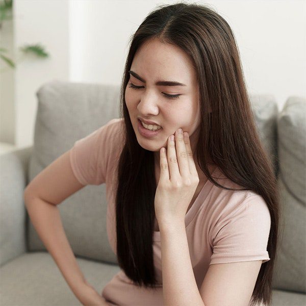 Young woman holding her jaw in pain