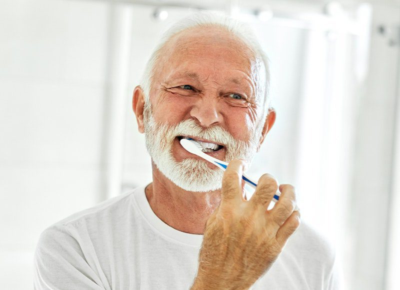 Elderly man maintaining oral hygiene