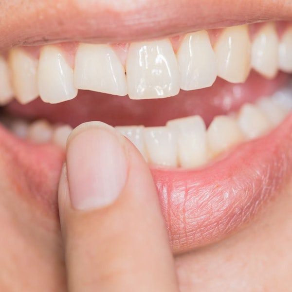 Smiling mouth with finger on lips